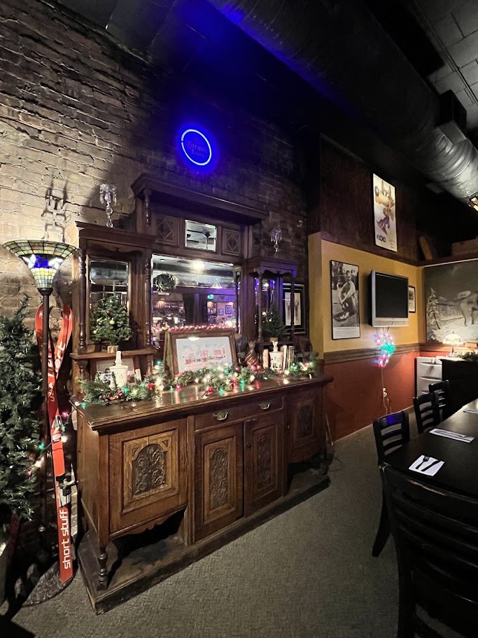 Warm interior with bar seating and pendant lights.